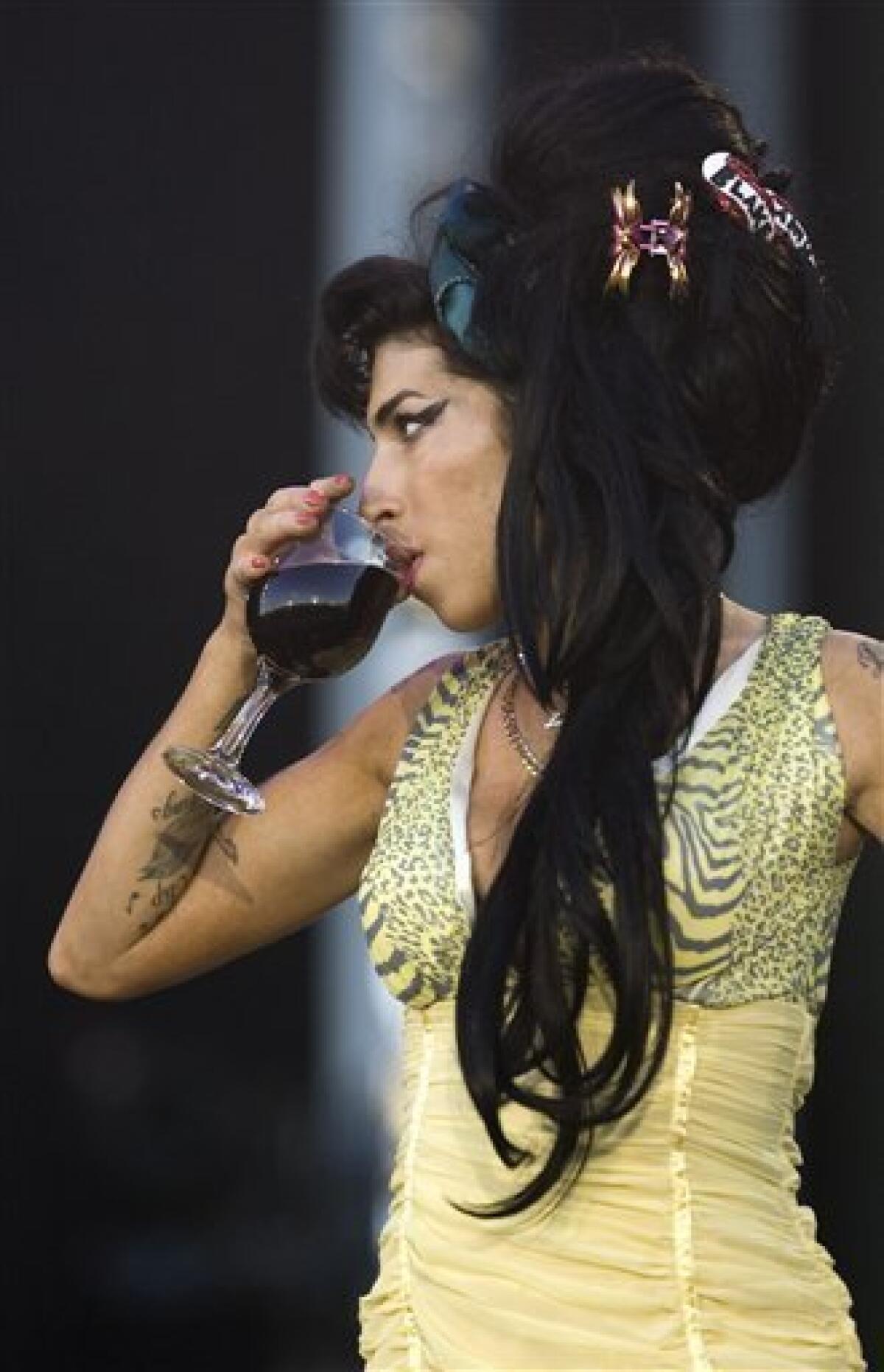 FILE - In this July 4, 2008 file photo, jazz soul singer Amy Winehouse, from England, performs during the Rock in Rio music festival in Arganda del Rey, on the outskirts of Madrid. Winehouse was booed and jeered late Saturday, June 18, 2011, during a concert in Serbia's capital as she stumbled onto the stage, mumbled through her songs and wandered off. (AP Photo/Victor R. Caivano, File) EDITORIAL USE ONLY