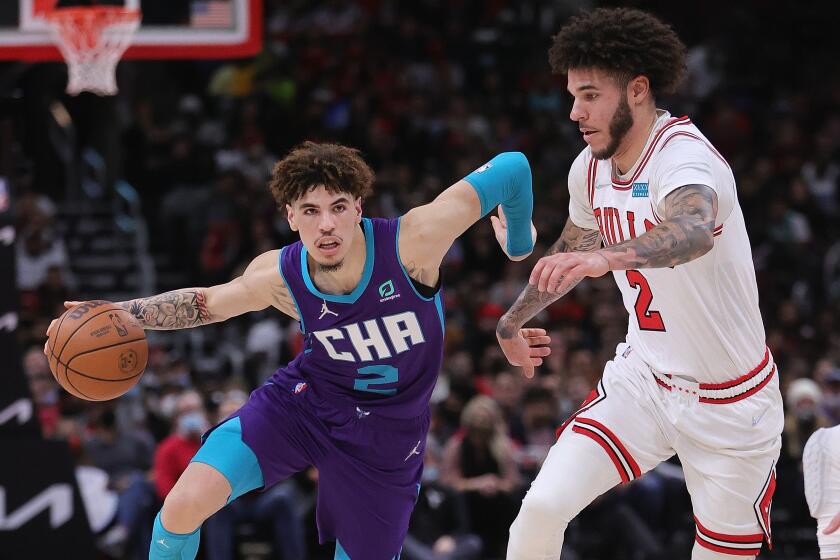 Hornets guard LaMelo Ball, left, drives against Bulls guard Lonzo Ball during a game.