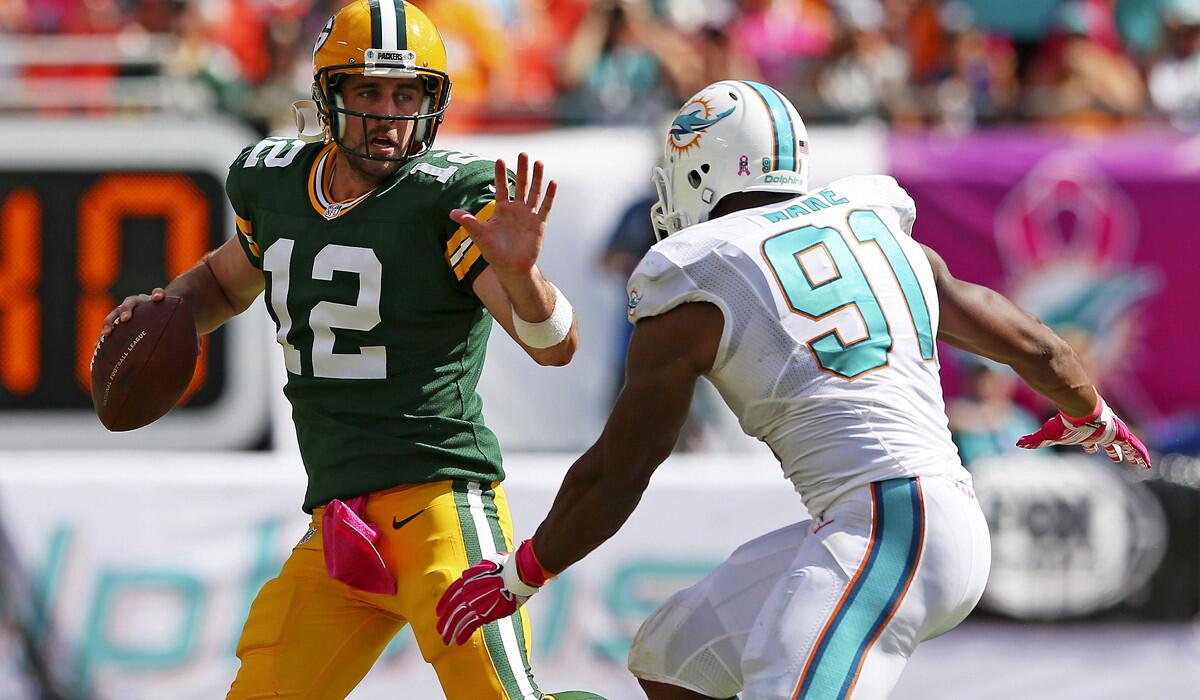Packers quarterback Aaron Rodgers looks to pass while under pressure from Miami defensive end Cameron Wake in the third quarter Sunday.