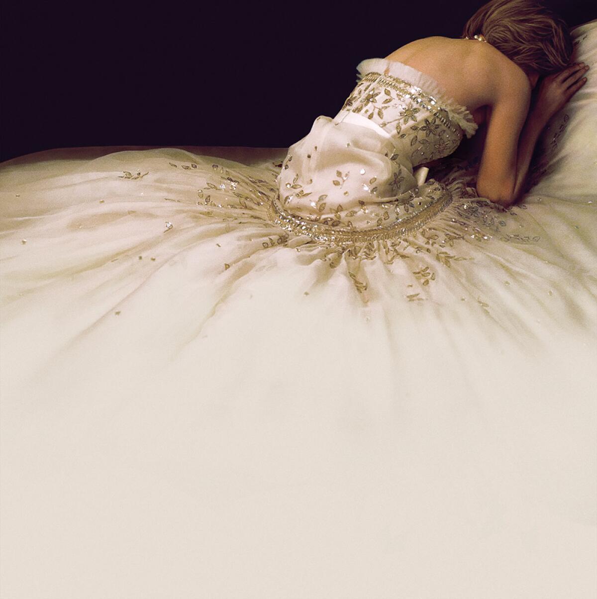 The back of a woman in a white gown leaning over