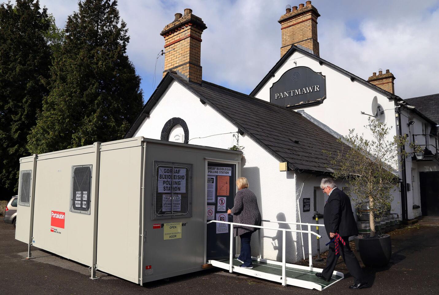 Voters arrive at a portacabin set up as a polling station near the Pantmawr Inn pub in Cardiff, South Wales.