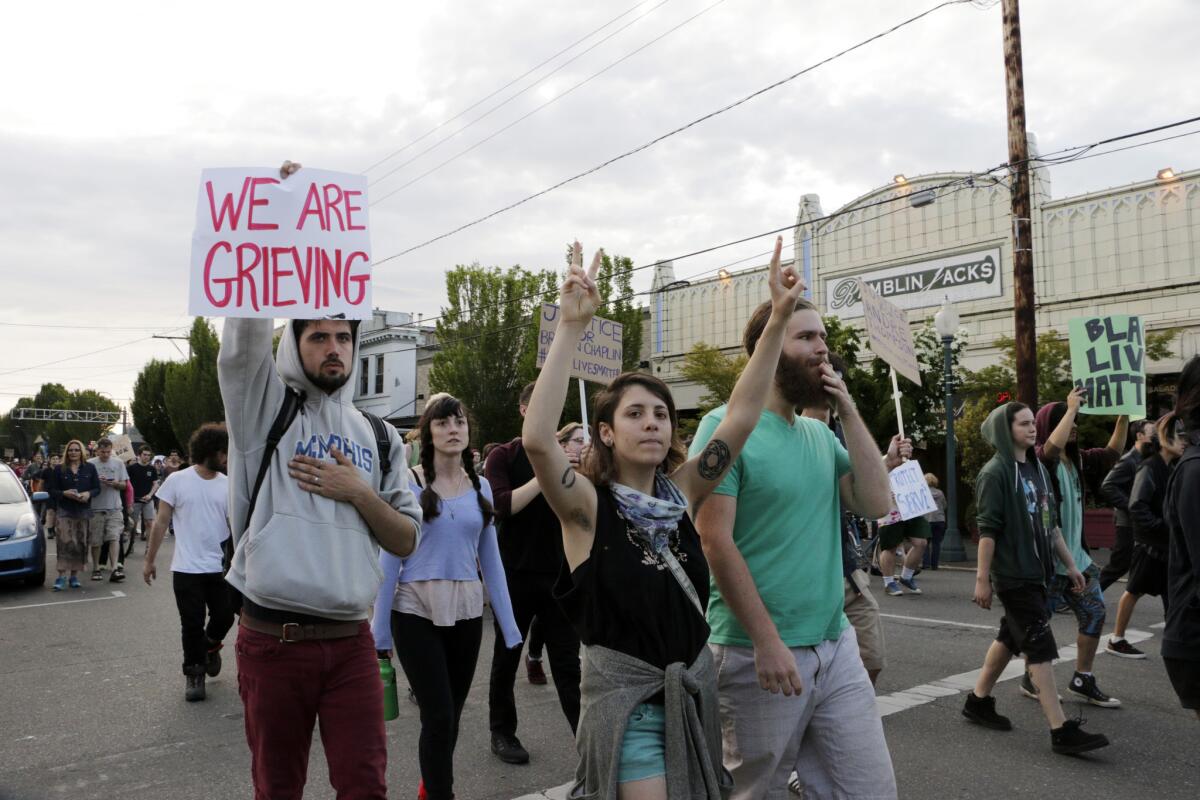 Protesters march toward City Hall in downtown Olympia, Wash., on Thursday, after a police officer shot two unarmed men.