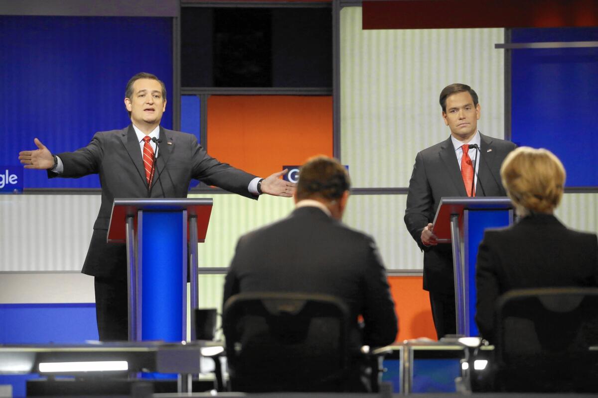 Ted Cruz makes a point as Marco Rubio listens during a Republican presidential primary debate Thursday in Des Moines.