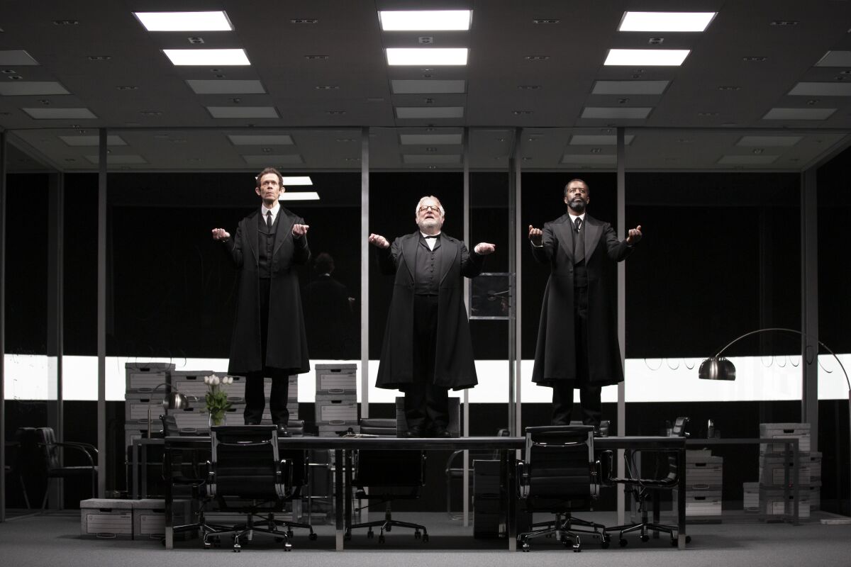 Three actors gesture onstage.