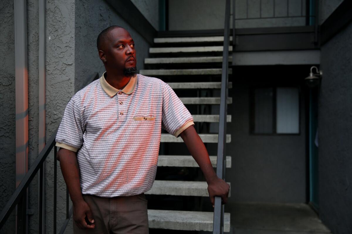 Terrance Stewart stands for a portrait outside the apartment where he has lived with his family in Colton, Calif. 