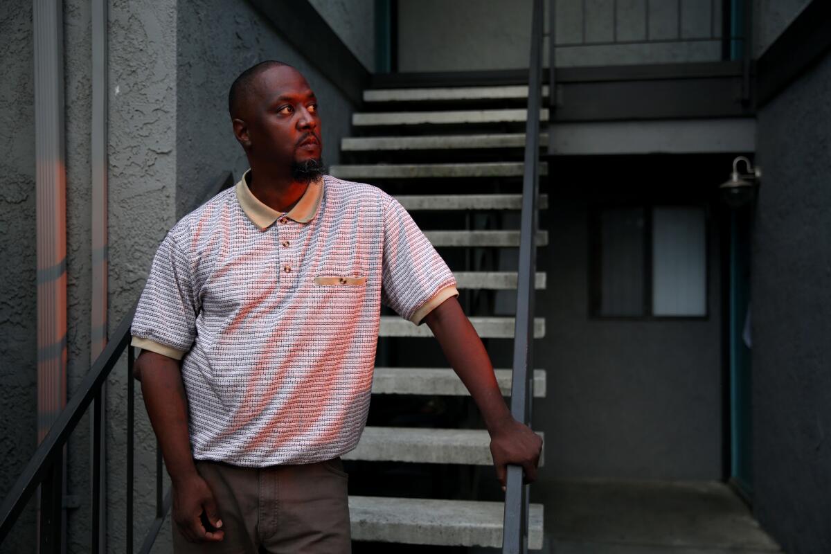 Terrance Stewart stands for a portrait outside the apartment where he has lived with his family in Colton, Calif.