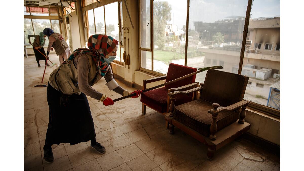 Student volunteers sweep up the fourth floor inside an administrative building near the library at Mosul University in Mosul, Iraq.