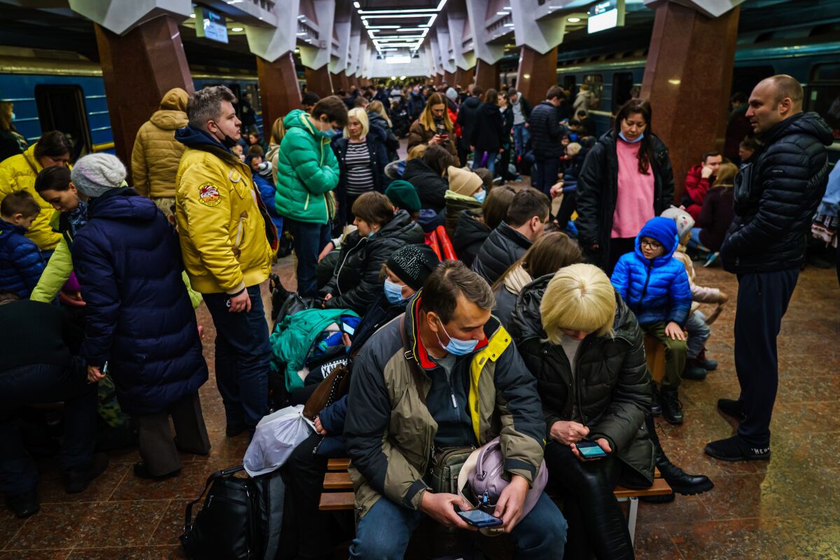 A crowded train station full of people with their belongings