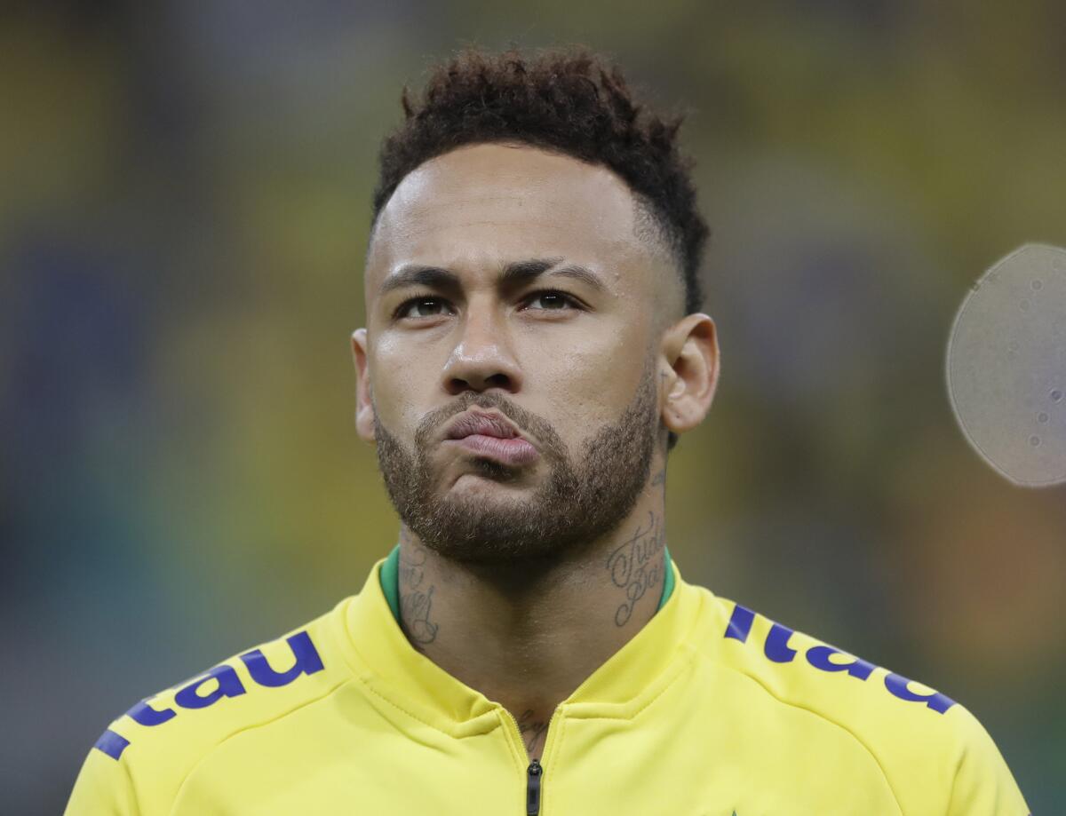 Neymar escucha con sus compañeros de la selección verde amarela el himno nacional brasileño antes del inicio del partido amistoso contra Catar en el estadio Nacional en Brasilia, el miércoles 5 de junio de 2019. (AP Foto/Andre Penner)