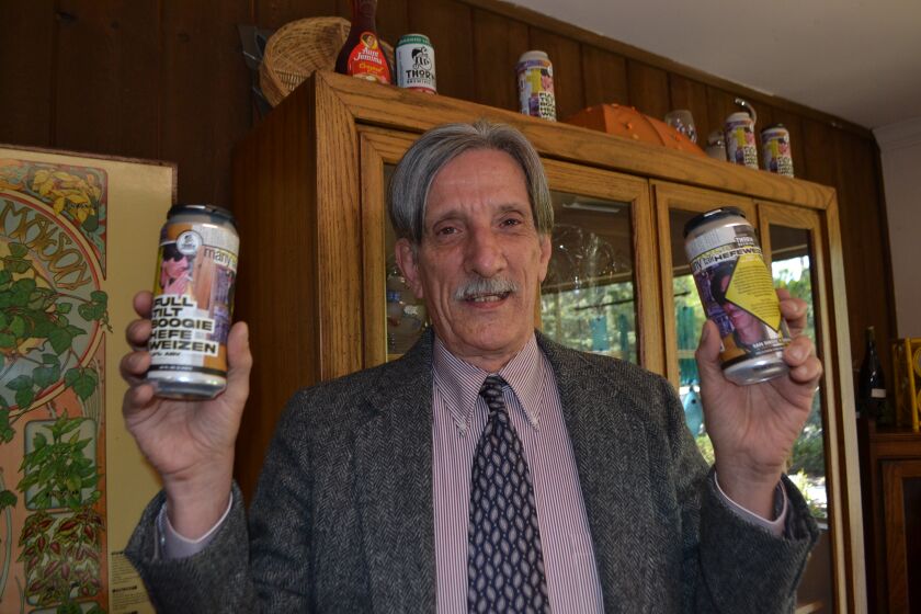 Roger Guy English holds cans of Full Tilt Boogie Hefeweizen, a Thorn Brewery beer he inspired.