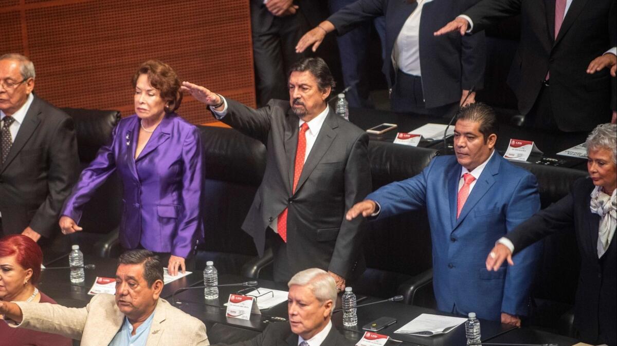 Napoleon Gomez Urrutia, center, is sworn in as a member of Mexico's Senate.