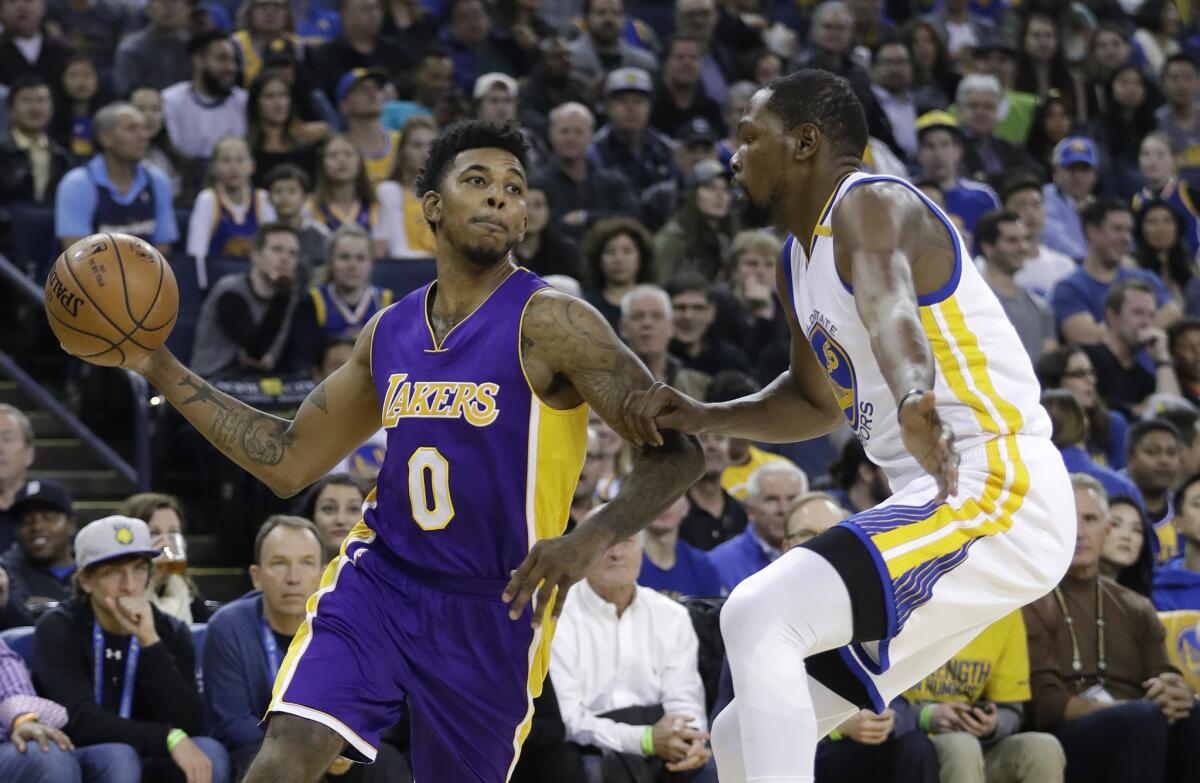 Lakers guard Nick Young is defended by Warriors forward Kevin Durant during the first half.
