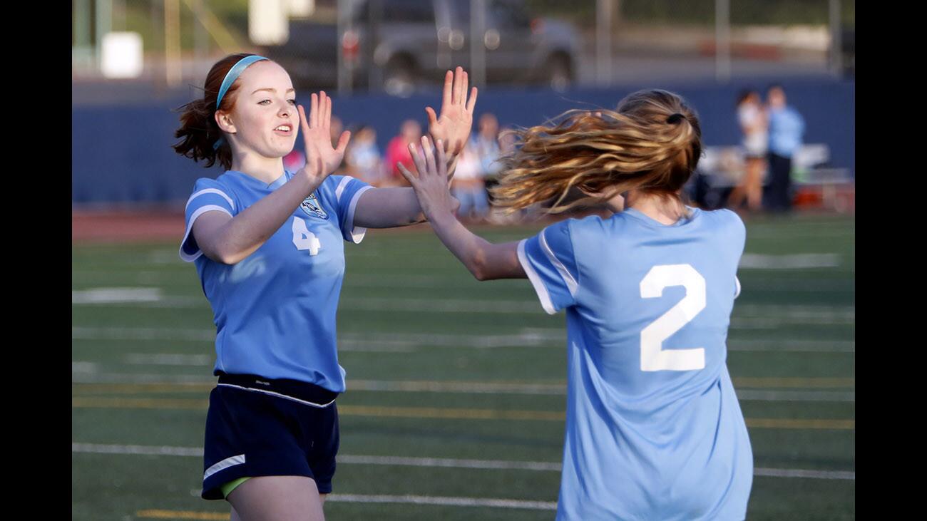 Crescenta Valley High School girls soccer player #4 Alaina Furstenberg gives #2 Dana Ryan a high five after Ryan scored a goal on a pass from Furstenberg in away game vs. Burbank High School, at the Bulldogs field in Burbank on Friday, Dec. 8, 2017.