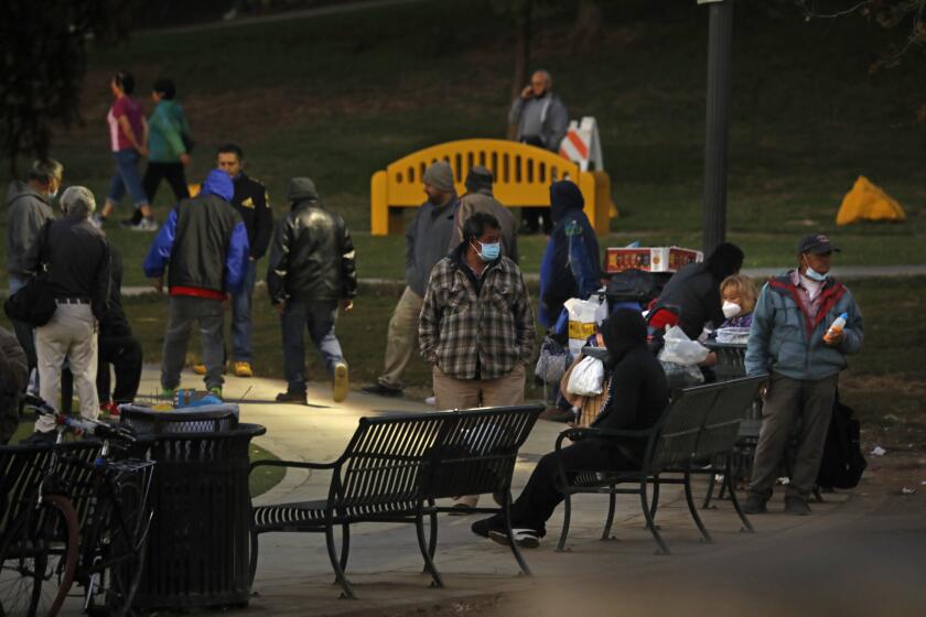 Los Angeles, California-Nov. 19, 2020-California will impose "limited" curfew due to COVID-19 surge. People gather outside at MacArthur Park on Nov. 19, 2020 at 5:00pm. (Carolyn Cole / Los Angeles Times)