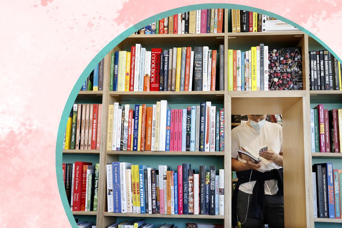 An opening in a bookshelf reveals a person reading a book 