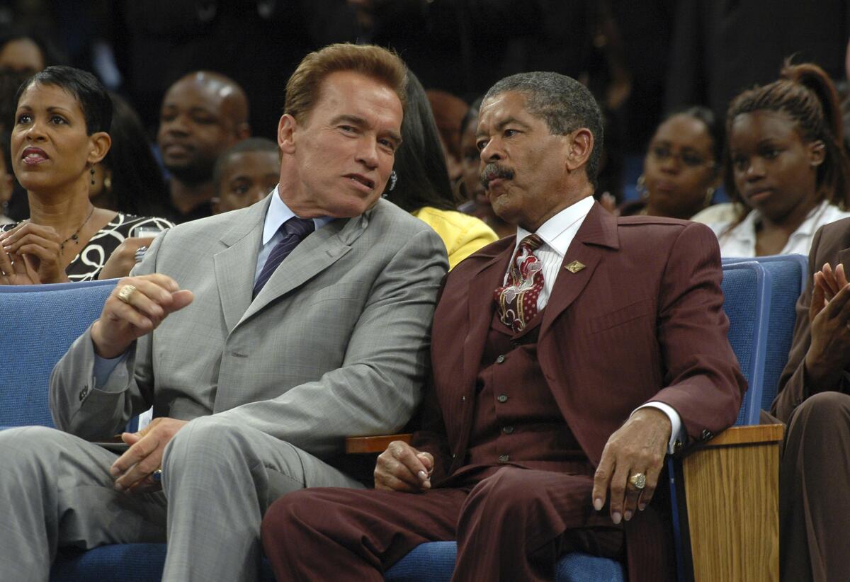 Arnold Schwarzenegger and Frederick K.C. Price sit next to each other