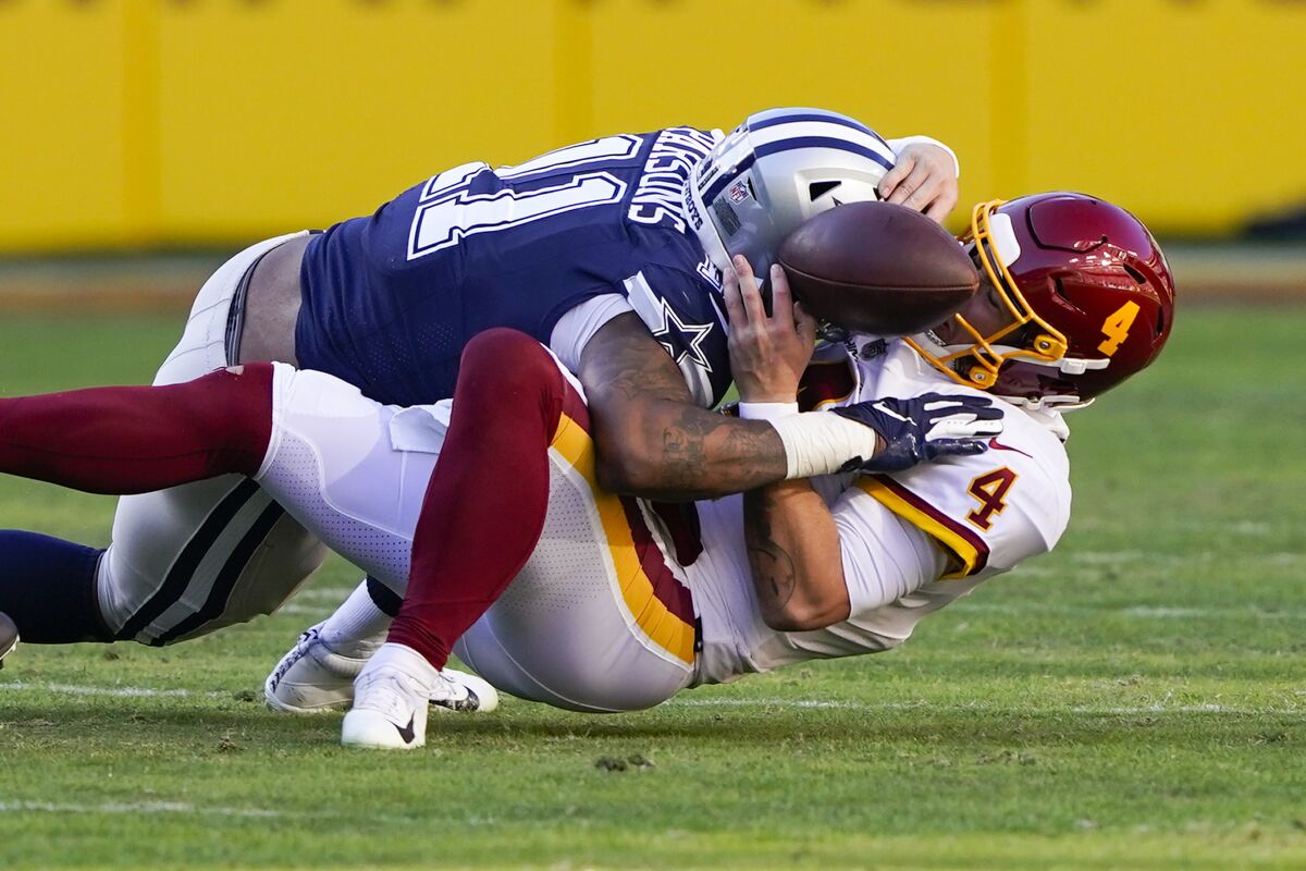 Washington quarterback Taylor Heinicke fumbles the ball as he is sacked by Dallas Cowboys outside linebacker Micah Parsons.