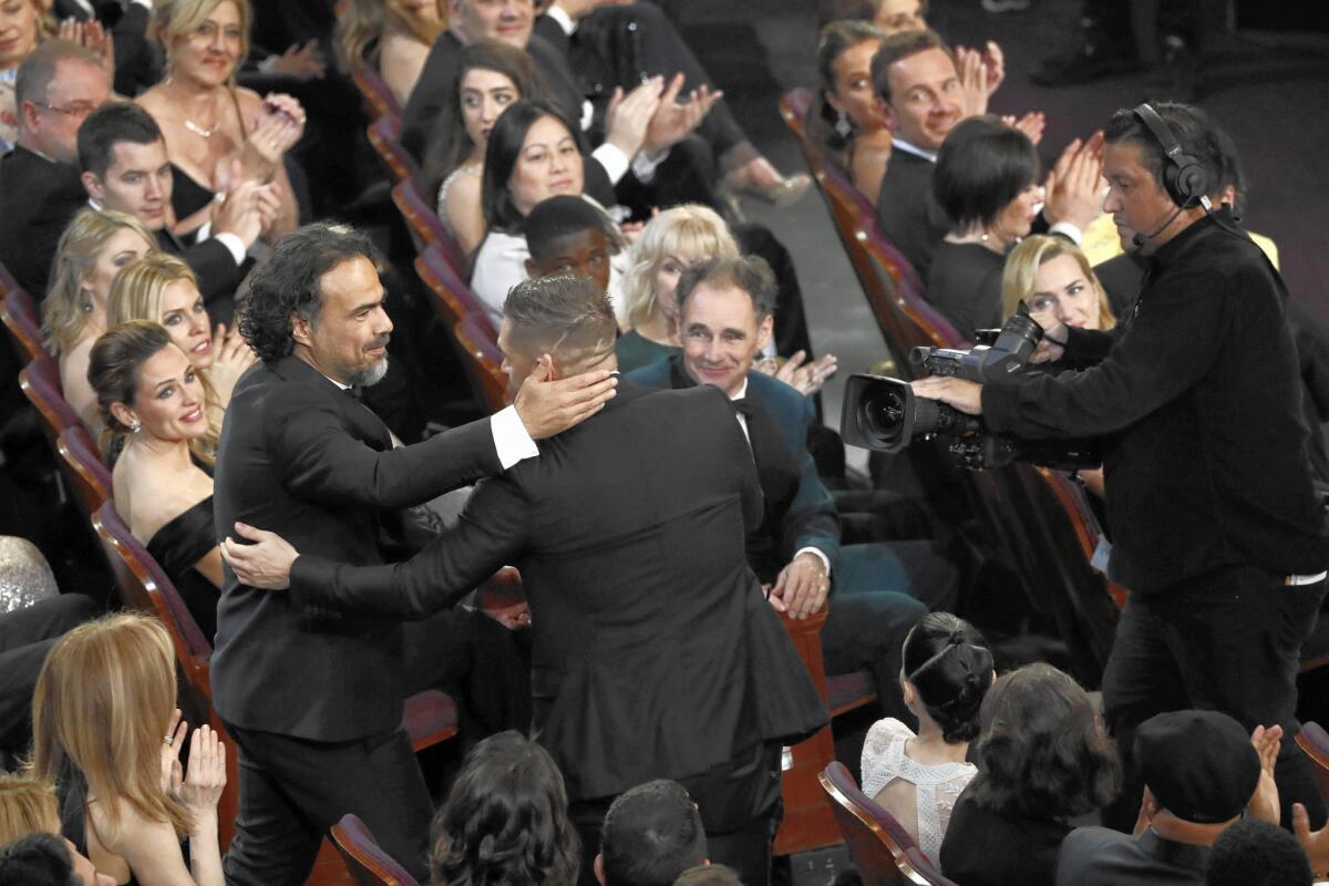 "The Revenant" director Alejandro G. Inarritu, left, is embraced by the film's supporting actor nominee, Tom Hardy, at the Oscars. Inarritu's win was his second straight in the director category. He won last year for "Birdman."