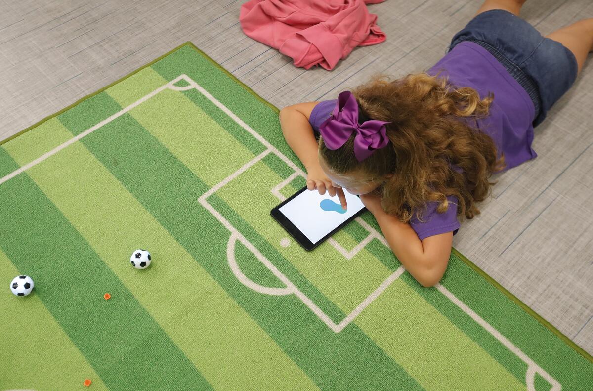 Ottavia Martinez moves a soccer ball from her iPad.