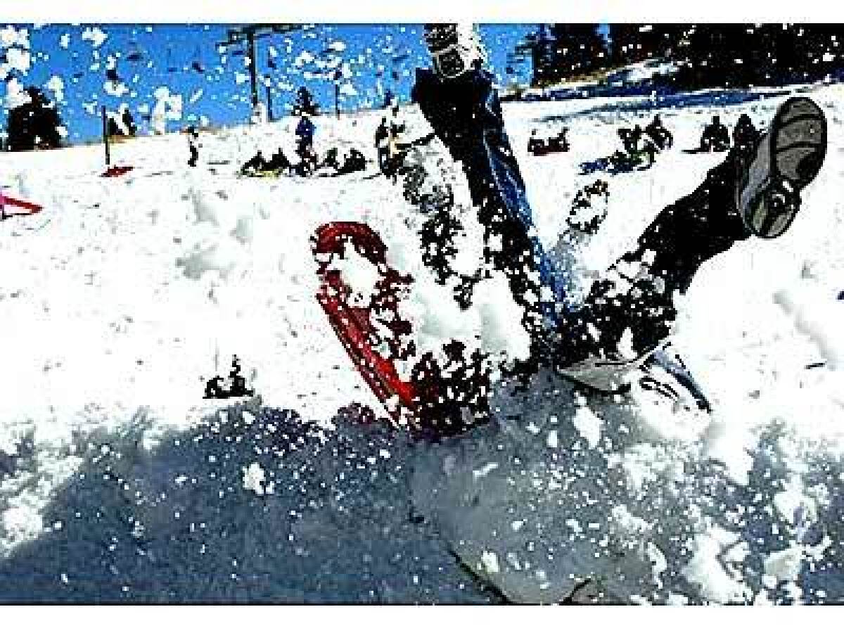 A sledder slides into a bank at the children's play area of Snow Valley Mountain Resort, which sits between Lake Arrowhead and Big Bear.