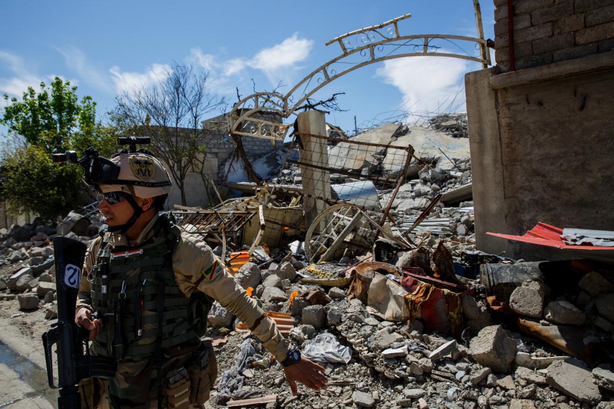 Iraqi security forces guard the ruins of Omar Hasan Abdul Qadir’s east Mosul home that he said was destroyed in an airstrike targeting Islamic State militants.