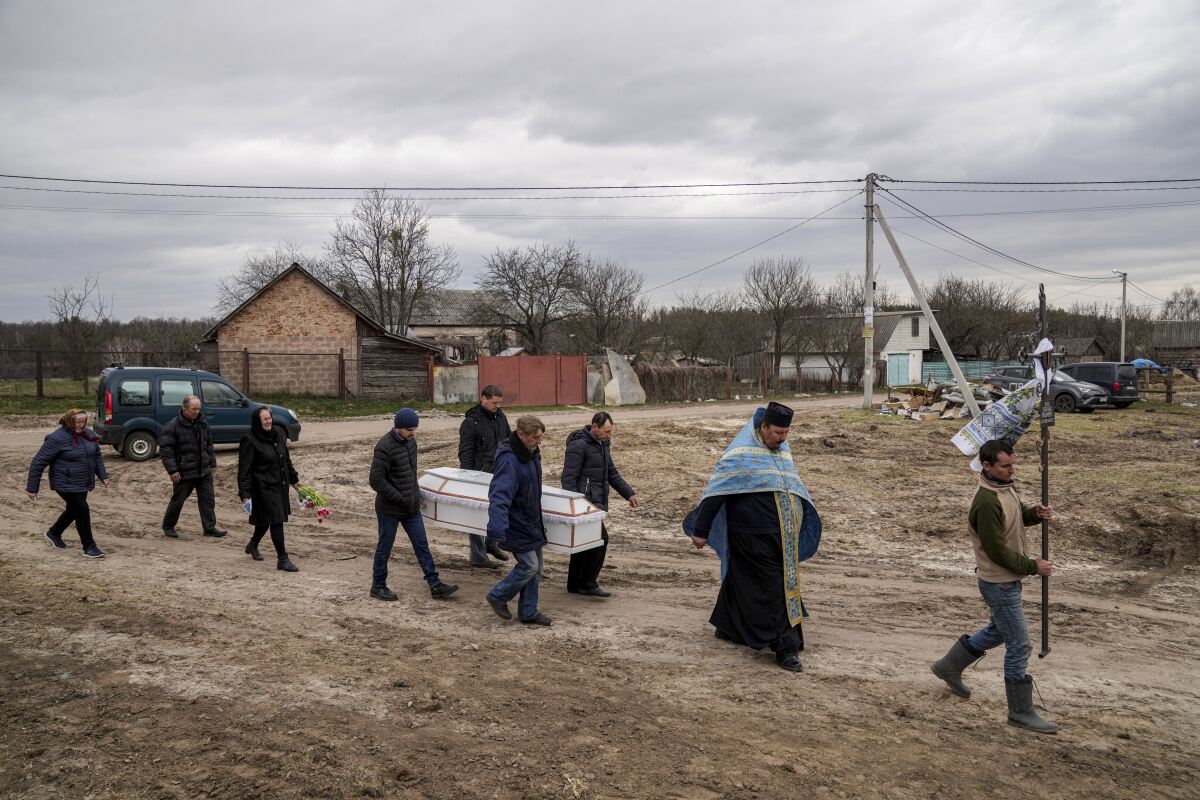 Liudmila Sumanchuk, third left, walks during the funeral ceremony for her granddaughter Veronika Kuts in Lgiv village, Chernihiv region, Ukraine, Friday April 8, 2022. Veronika Kuts who was 12-year-old was killed during a Russian airstrike. (AP Photo/Evgeniy Maloletka)