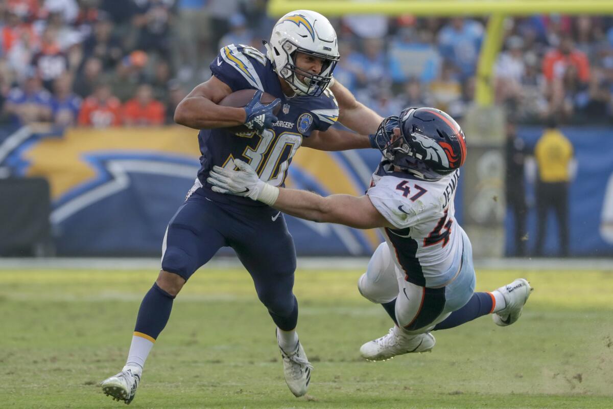 Chargers running back Austin Ekeler pushes away Denver Broncos linebacker Josie Jewell during a fourth quarter run at Stubhub Center on Nov. 18, 2018.