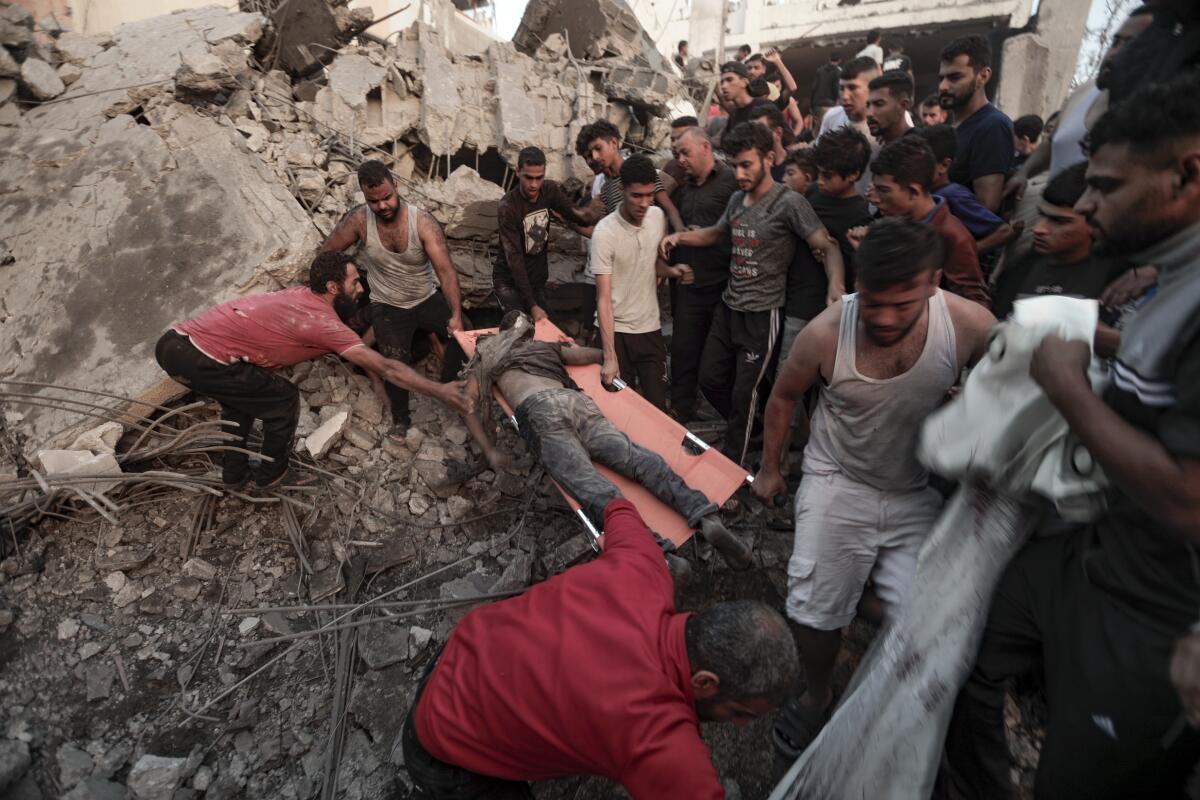 Palestinians carry the body of a man recovered from the rubble of a home in Khan Younis, Gaza Strip.
