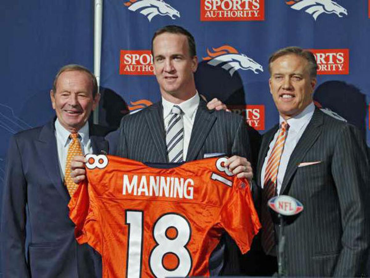 New Denver Broncos quarterback Peyton Manning, center, is flanked by Broncos owner Pat Bowlin, left, and vice president John Elway during a news conference.