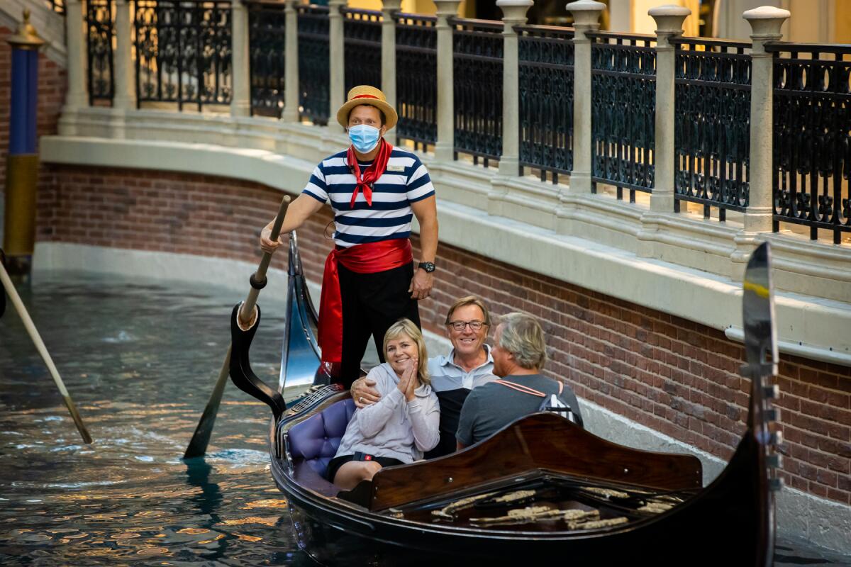 A masked gondolier ferries visitors at the Venetian Resort, which is offering deals for the summer.