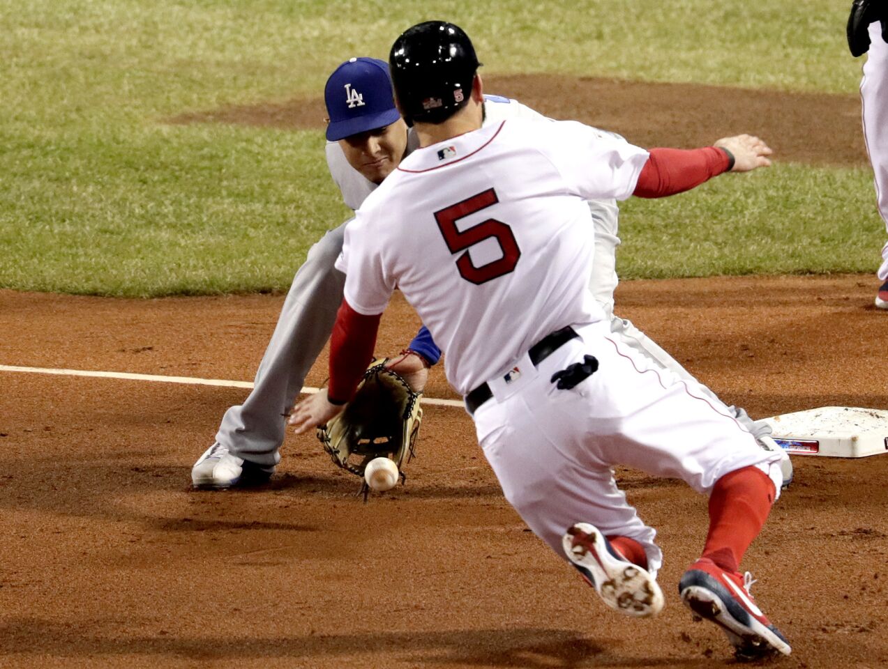 Dodgers' Manny Machado gets the ball ahead of Red Sox Ian Kinsler to tag him out at third base.