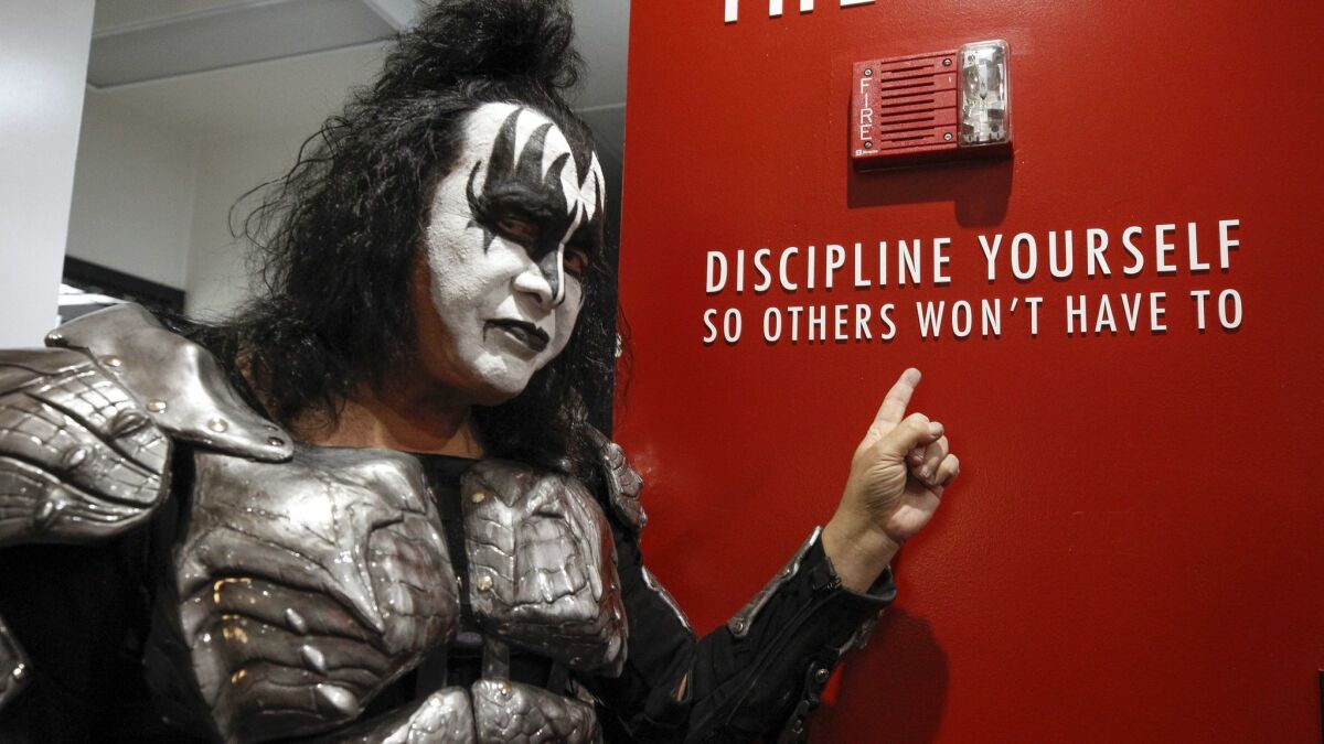 KISS bass player Gene Simmons points to writing on a wall during a meet-and-greet with fans before the start of the End of the Road tour.