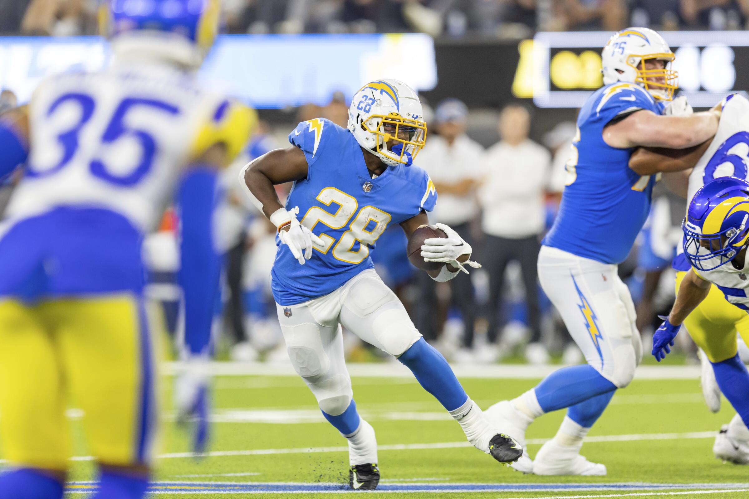Chargers running back Isaiah Spiller tries to run past the Rams defense.