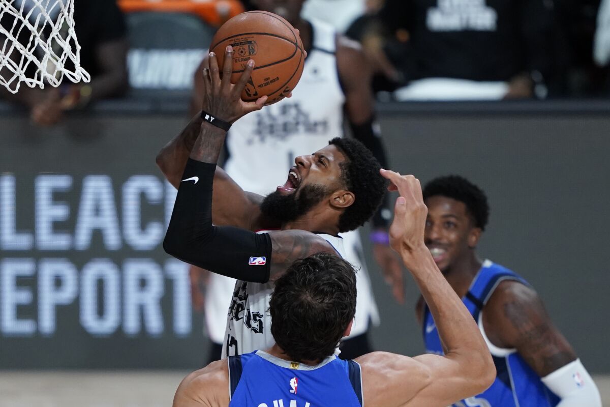 Paul George, drives to the basket against the Dallas Mavericks during the second half.