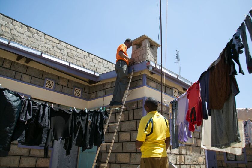StarTimesâ sole salesman in Kajiado, installs a StarTimes satellite dish on Francis Gitongaâs Roof