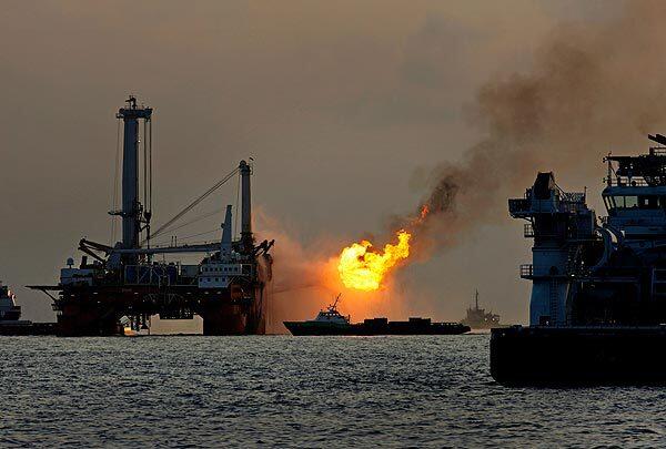 Support vessels surround the Q4000, left, in the Gulf of Mexico. The platform operated briefly Thursday during a testing problem, but it stopped collecting and burning off oil from BP's leaking well after the well was sealed for the first time since the disaster began in April.