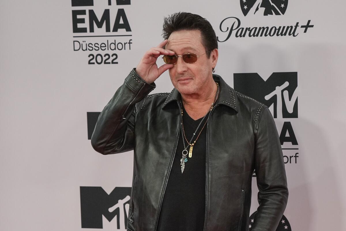 Julian Lennon in sunglasses and leather jacket.