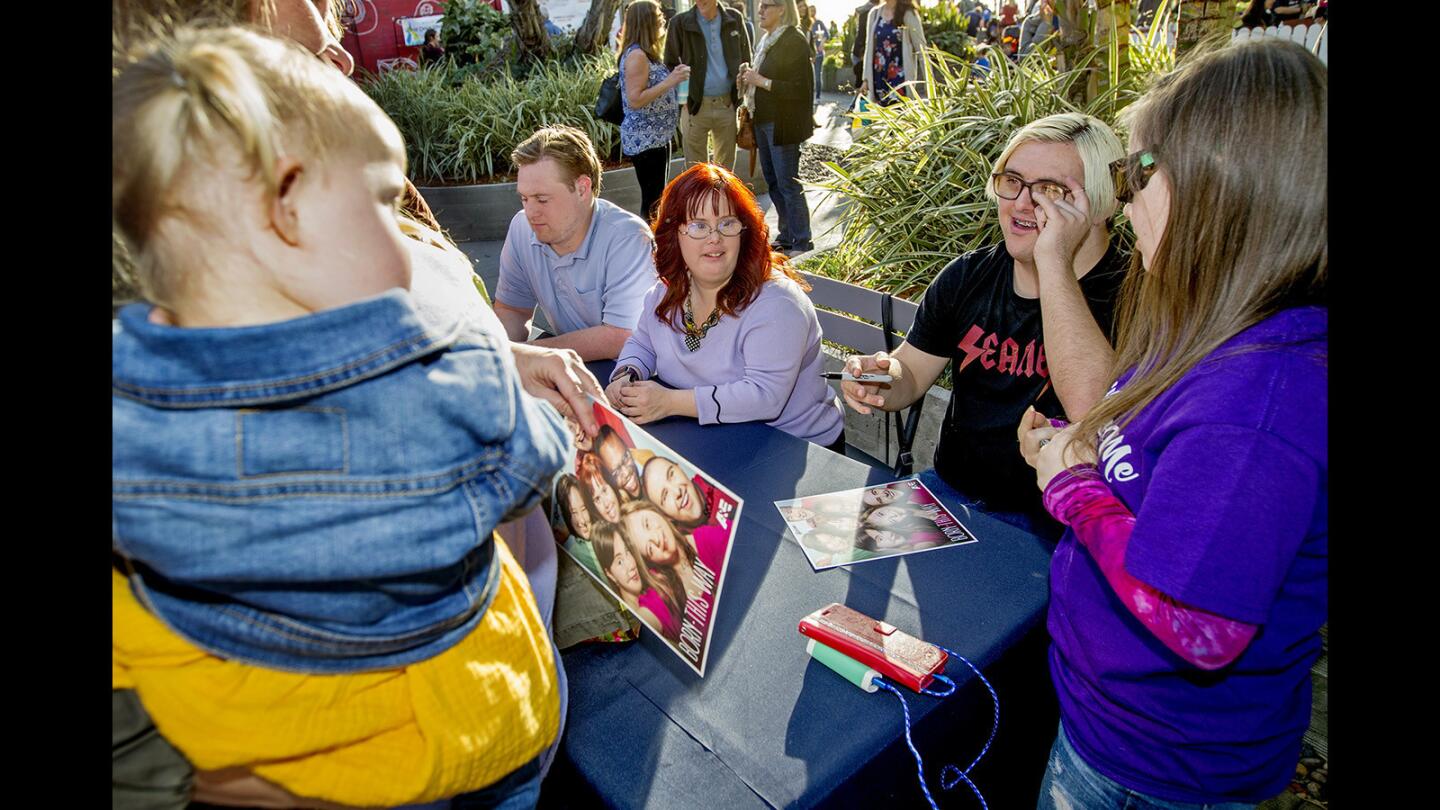 Cast members of the A&E show "Born This Way," from right, Megan Bomgaars, Sean McElwee, Rachel Osterbach and Steven Clark sign autographs at Wednesday's World Down Syndrome Day at Pacific City in Huntington Beach.