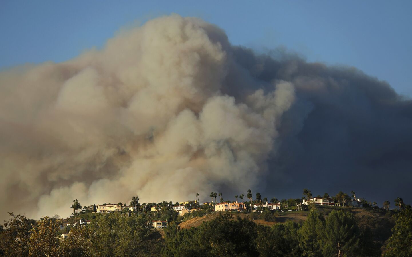 A giant plume of smoke from the Woolsey Fire rises above homes in Calabasas.