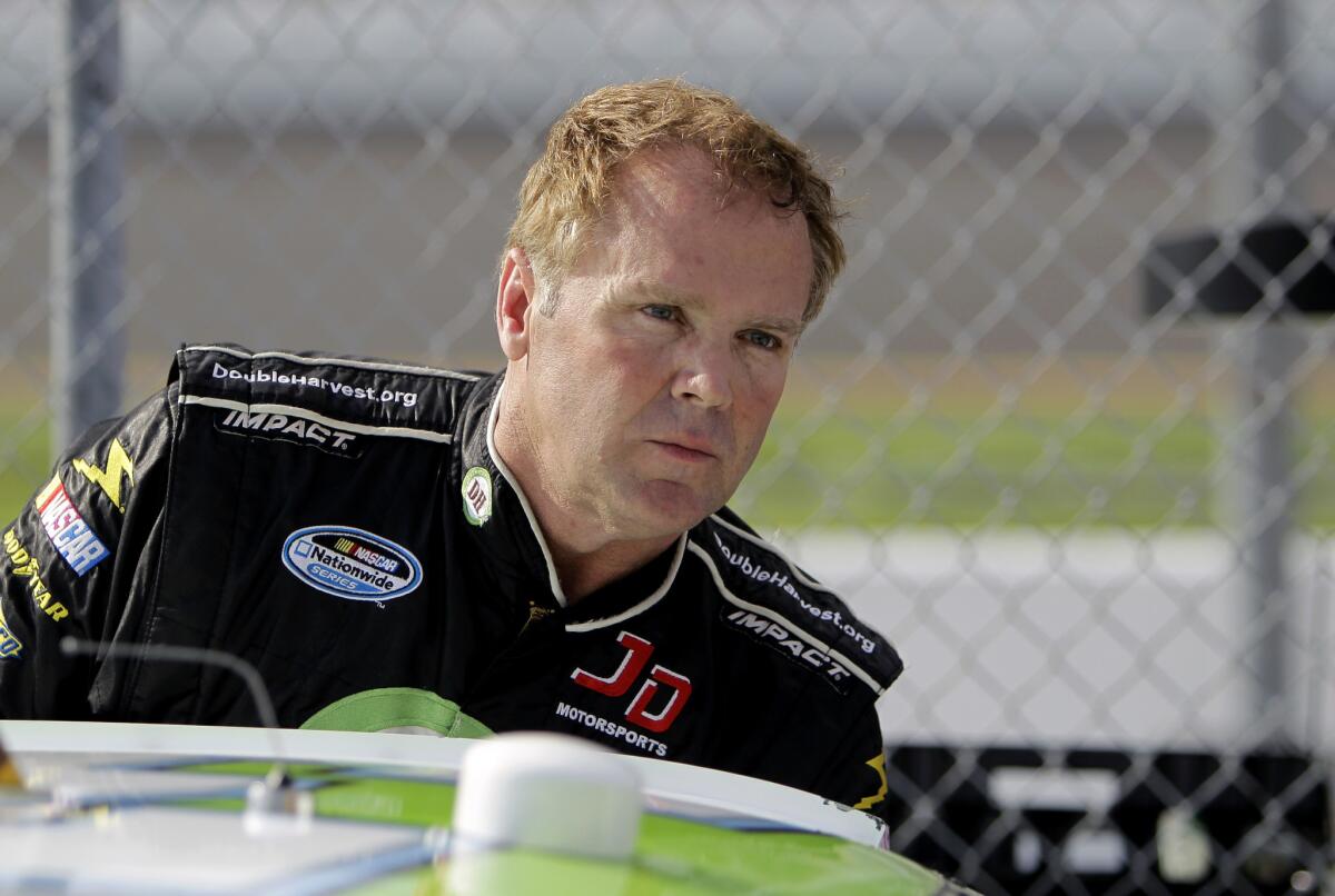 NASCAR driver Mike Wallace climbs out of his car at Daytona International Speedway on Feb. 19, 2012.