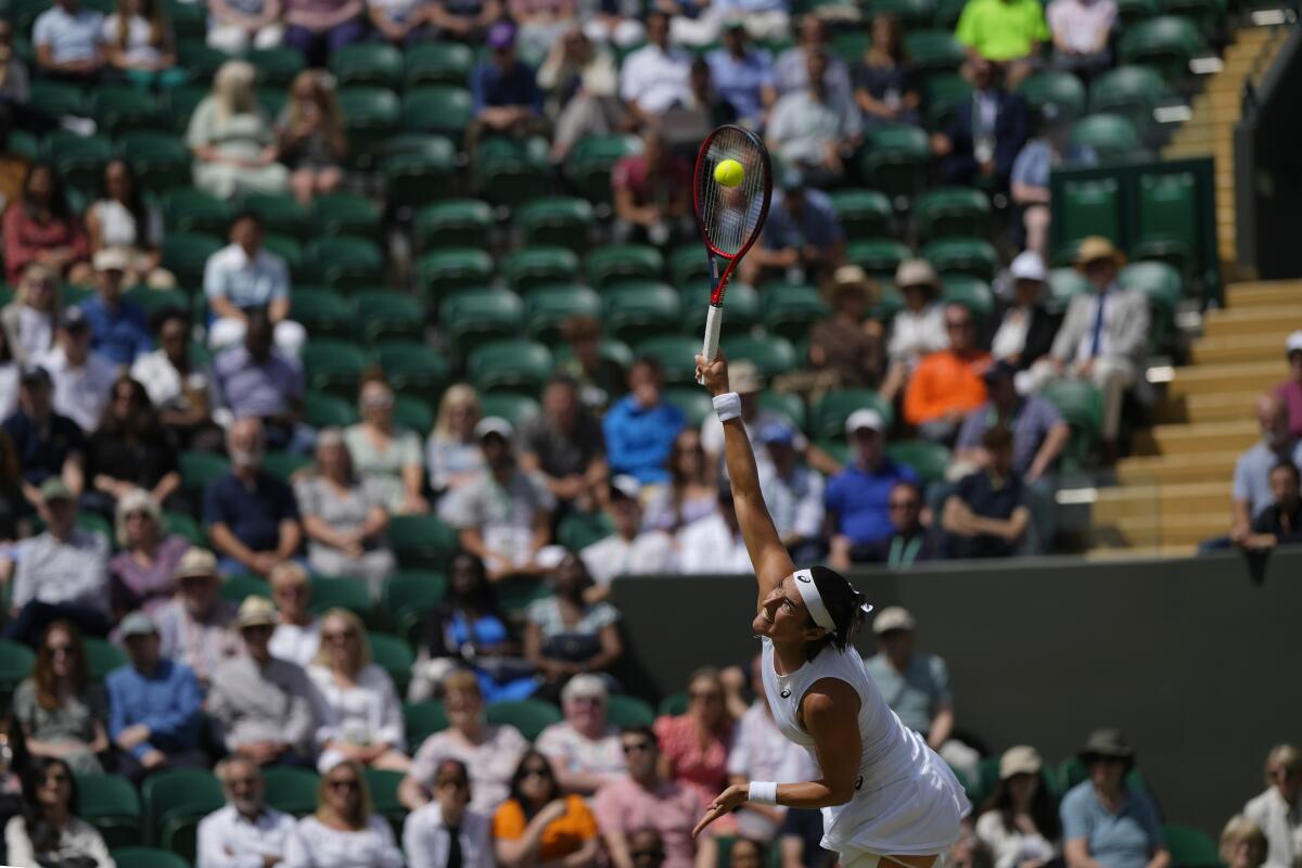 France's Caroline Garcia serves to Marie Bouzkova of the Czech Republic in a fourth round women's singles match on day seven of the Wimbledon tennis championships in London, Sunday July 3, 2022. (AP Photo/Alastair Grant)