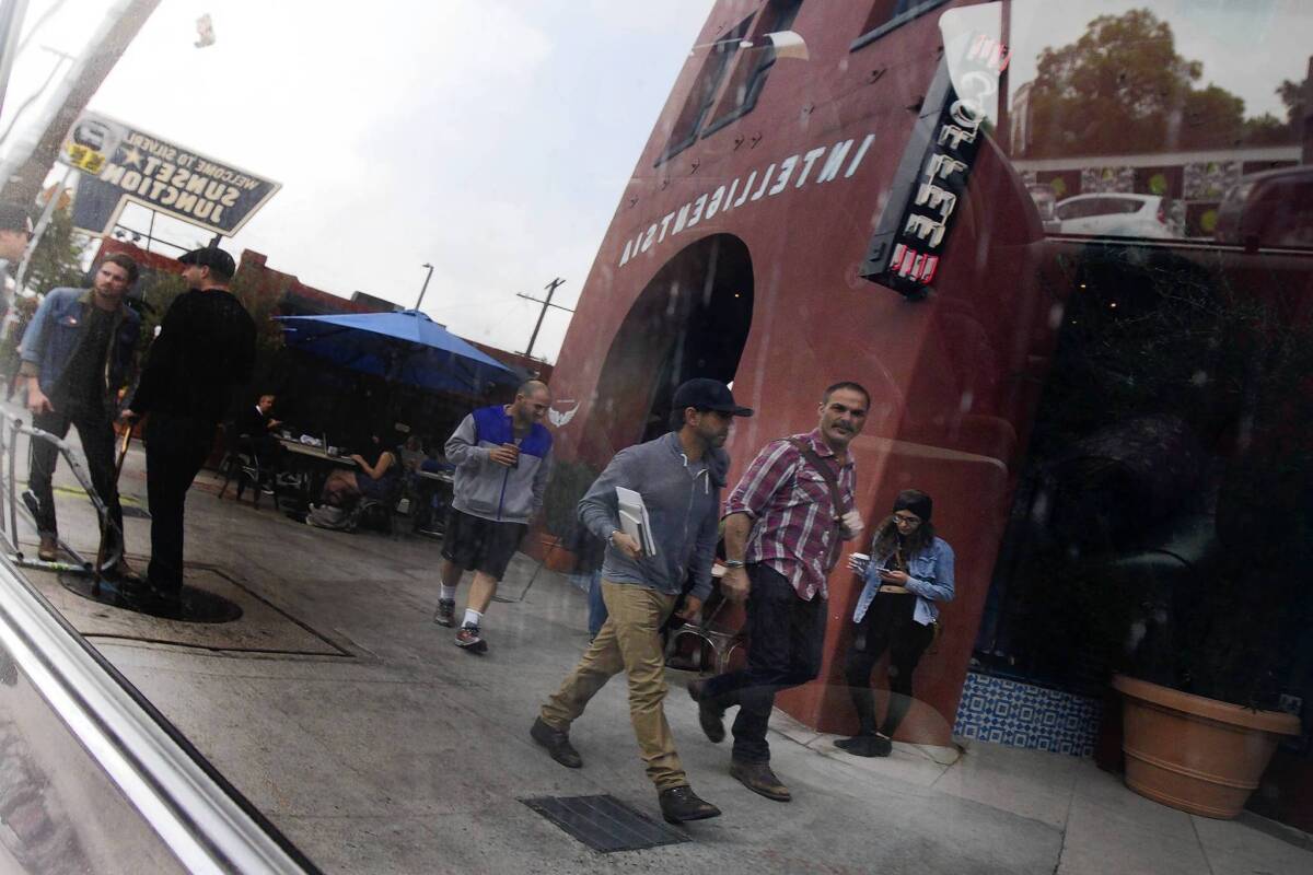 Intelligentsia Cafe is reflected in a car window on Sunset Boulevard in Silver Lake. Parking has become a serious problem as the neighborhood grows.