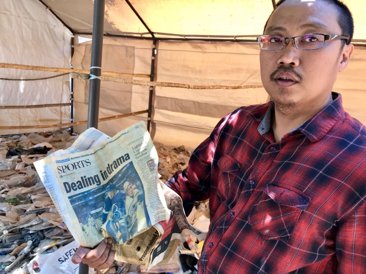 Prigi Arisandi, director of the Indonesian conservation group Ecoton, shows a copy of the February 26, 2019, edition of the Tampa Bay Times. The sports page was part of a shipment of U.S. household trash that was imported in violation of Indonesian customs laws.