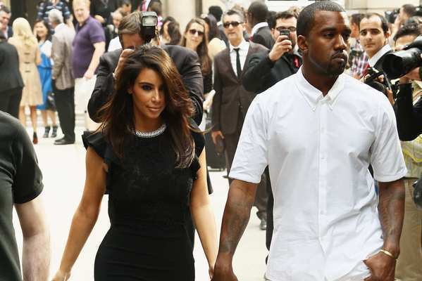 Kim Kardashian and Kanye West leave the Valentino haute-couture show during Paris Fashion Week at Hotel Salomon de Rothschild on July 4, 2012.