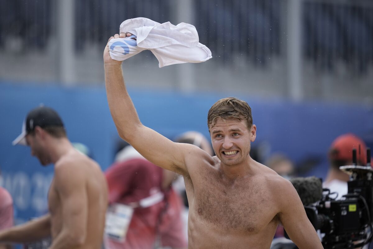 Christian Sandlie Sorum, of Norway, waves a jersey that he exchanged with the Russian Olympic Committee team member as he celebrates winning a men's beach volleyball Gold Medal match at the 2020 Summer Olympics, Saturday, Aug. 7, 2021, in Tokyo, Japan. (AP Photo/Felipe Dana)