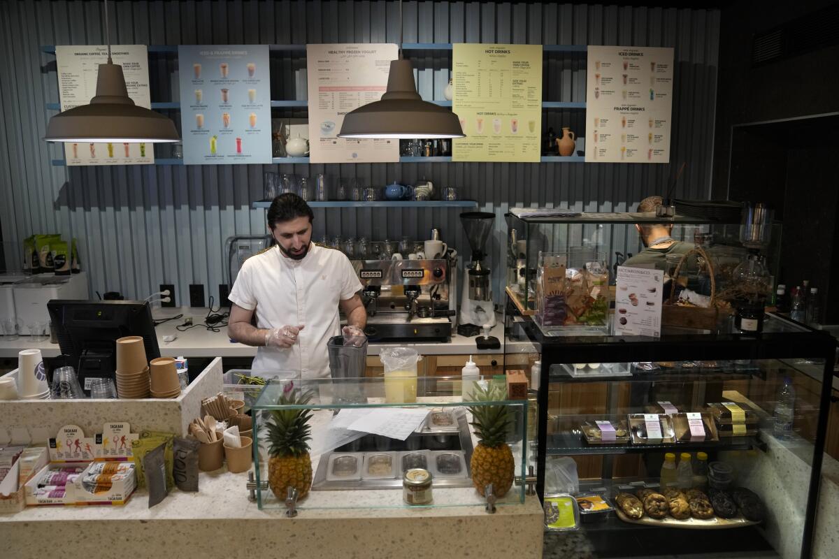Abbas Bazzi prepares drinks at Le Marché Bio, the organic cafe and grocery store he co-owns, in Beirut.