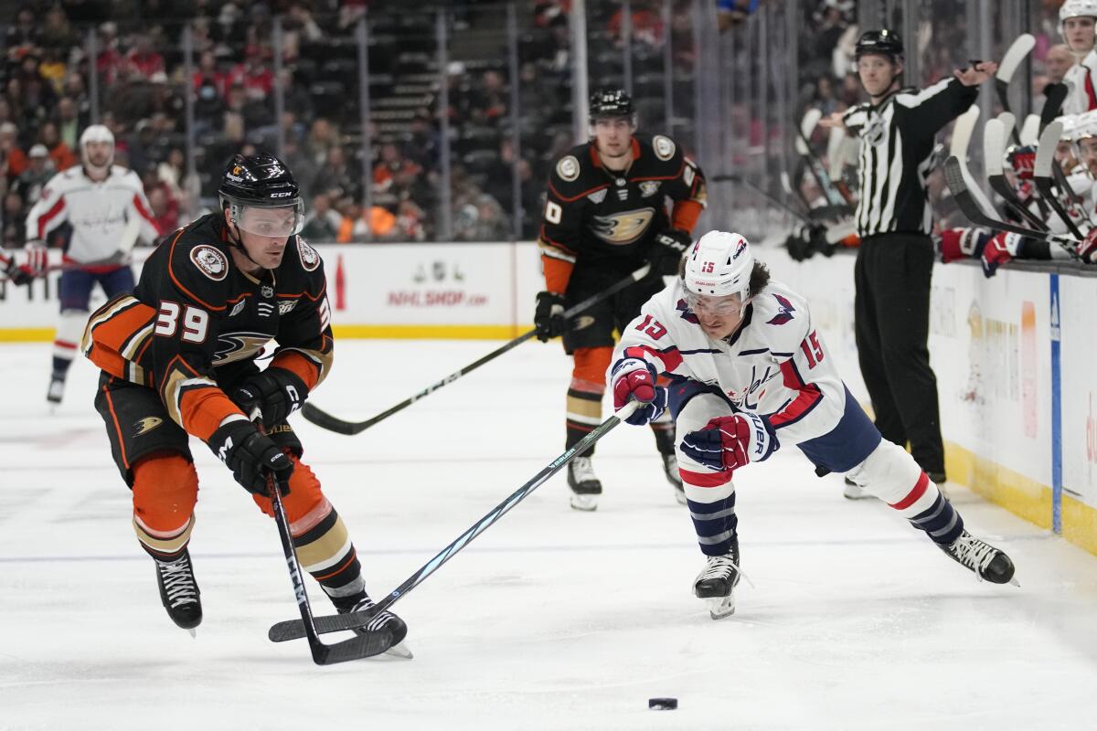 Ducks forward Sam Carrick, left, and Washington Capitals forward Sonny Milano reach for the puck during the second period.