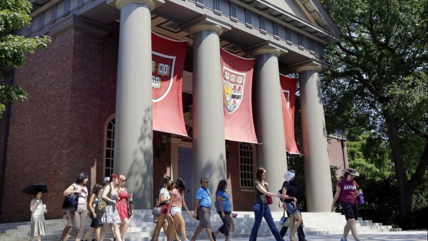 A tour group walks through the campus of Harvard University in Cambridge, Mass.