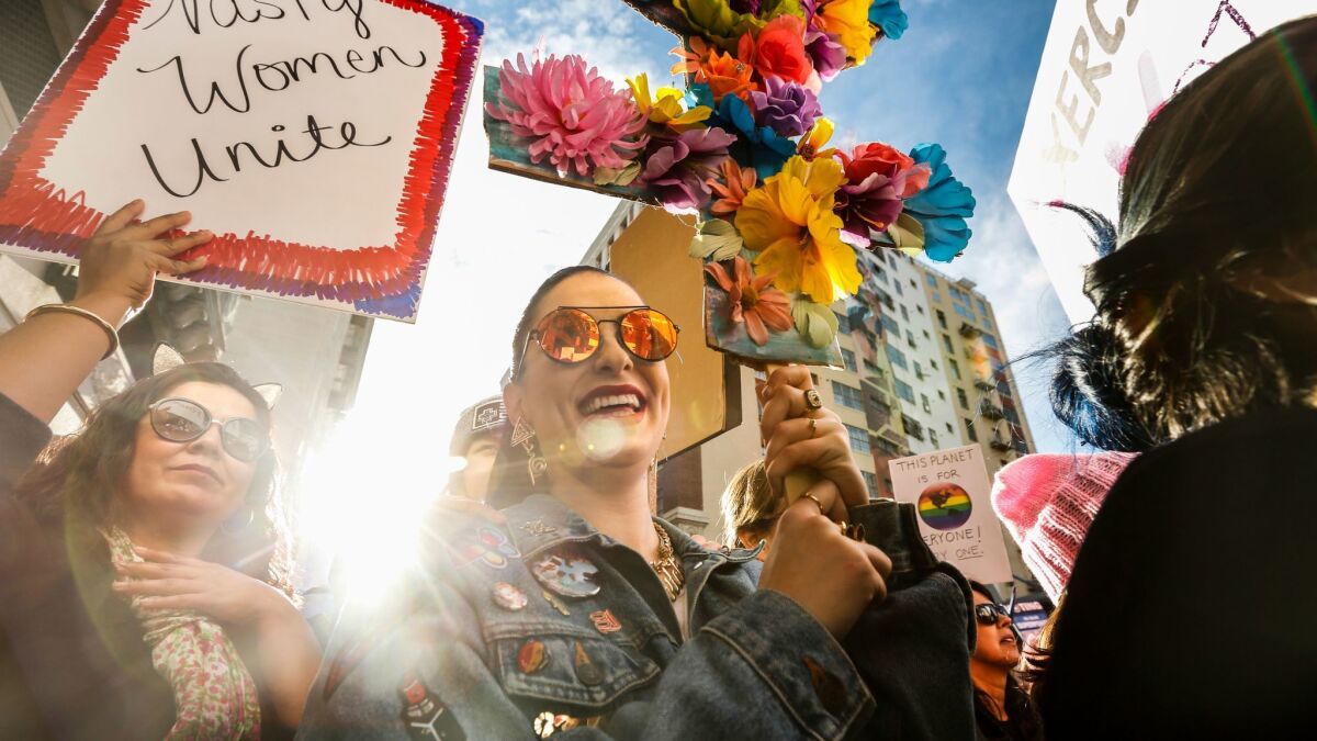 Mary Macintyre, 25, holds an LGBTQ symbol made of flowers as more than 500,000 people participate in the Women's March of Los Angeles.