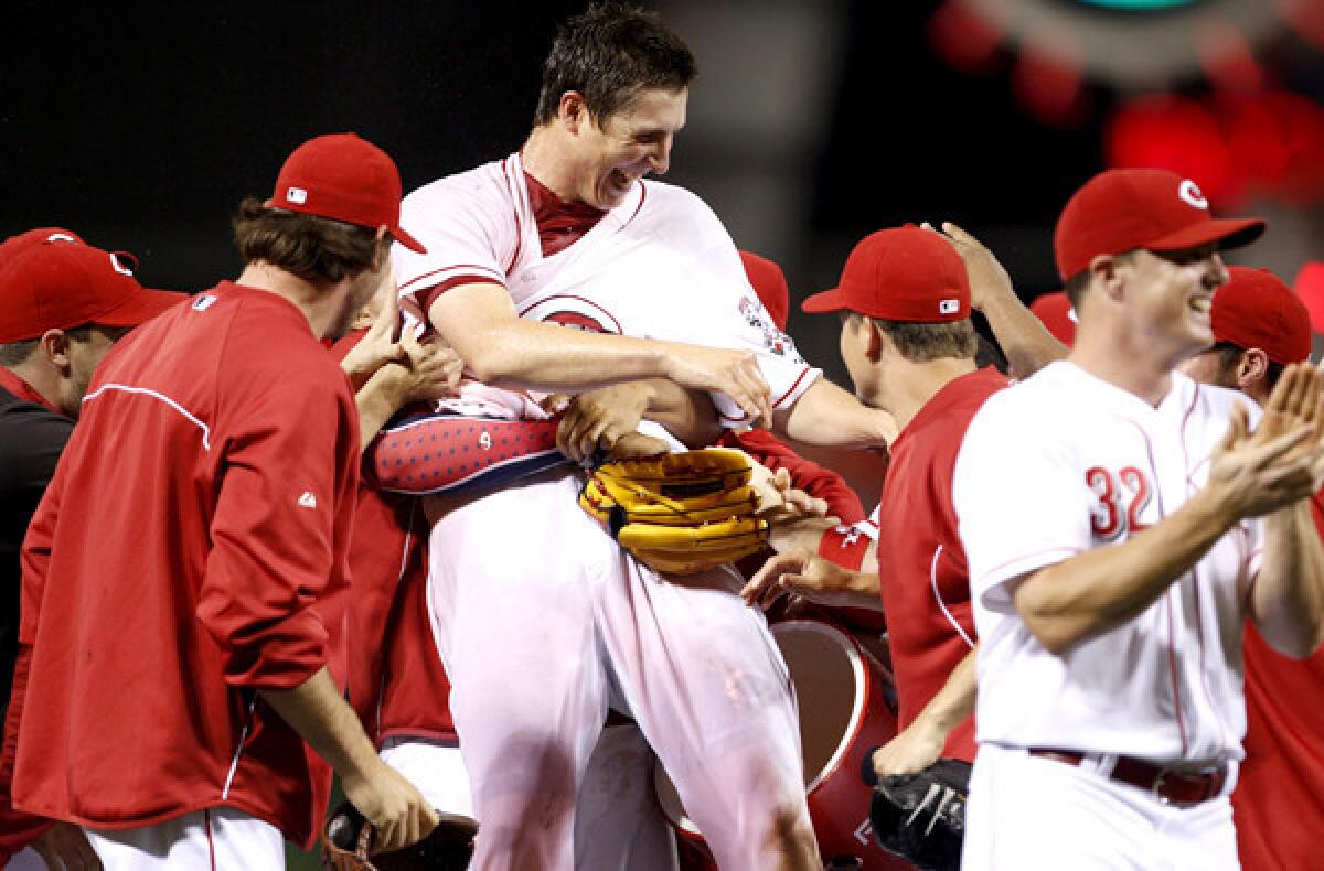 Reds pitcher Homer Bailey is swarmed by teammates after completing a no-hitter against the San Francisco Giants on Wednesday night in Cincinnati.